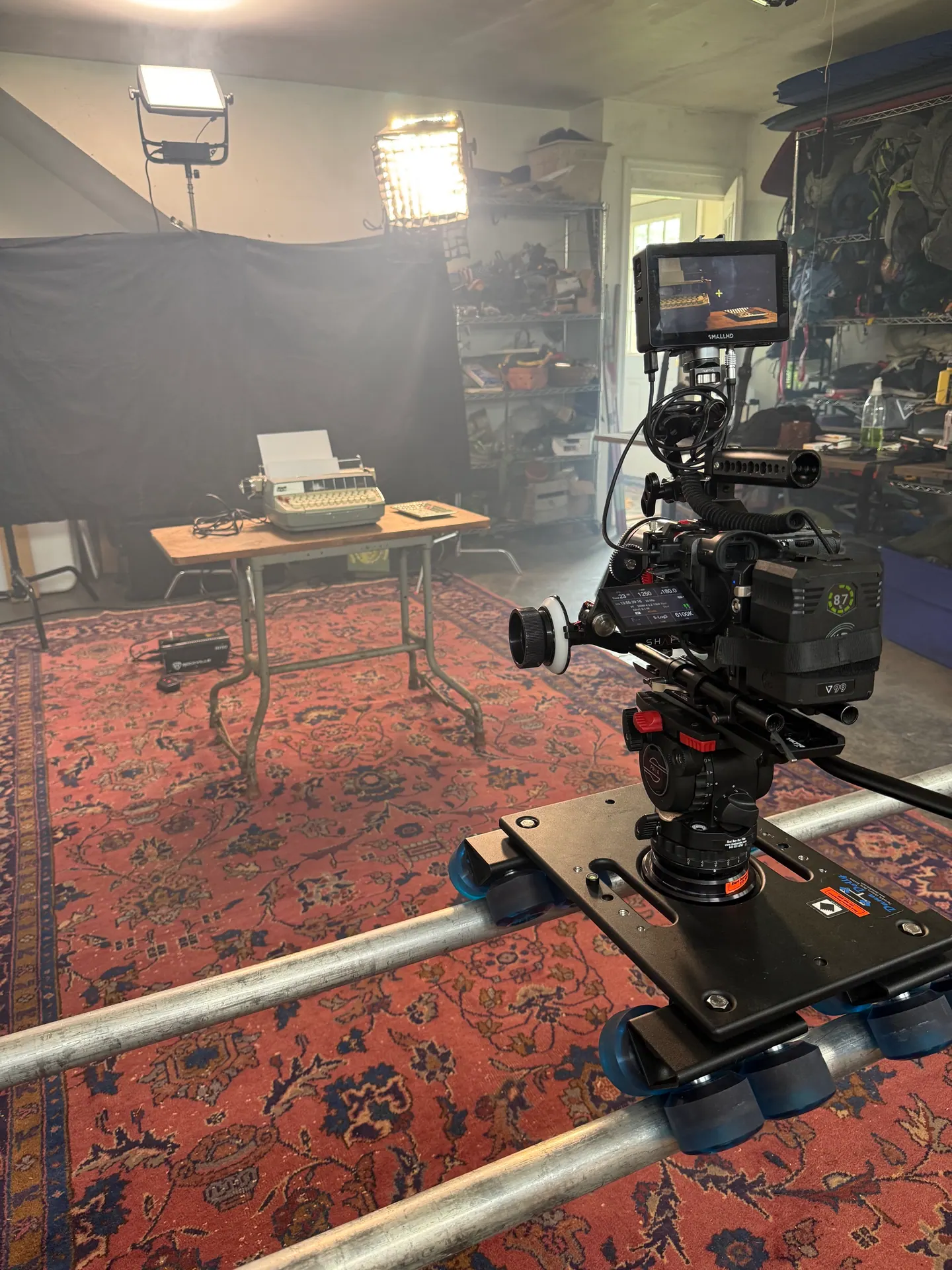 Camera on a dolly track aimed at a typewriter set.