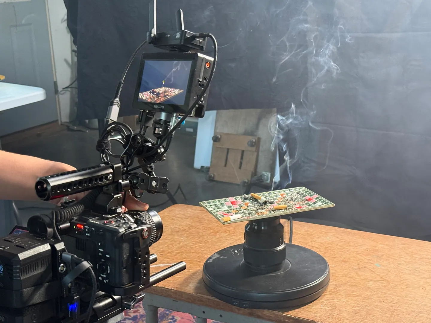 Camera rig filming a smoking ashtray on a turntable.