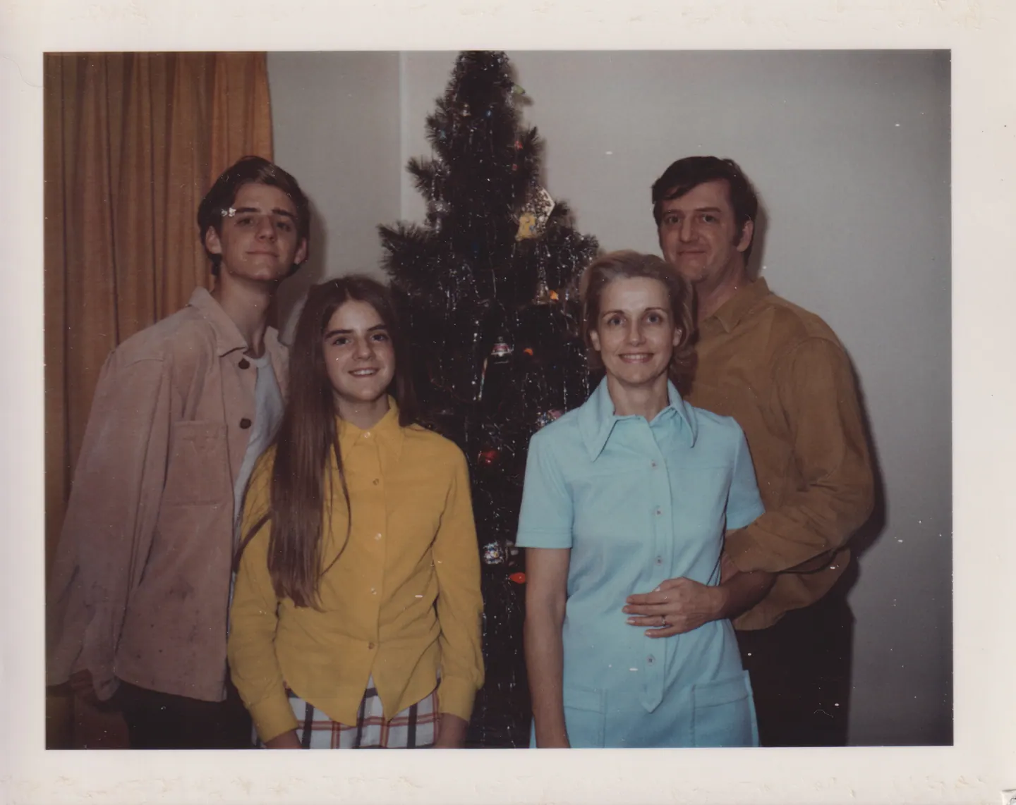 Jeff, Lila, Helen and Michael Shaara stand before a Christmas tree, 1970s.